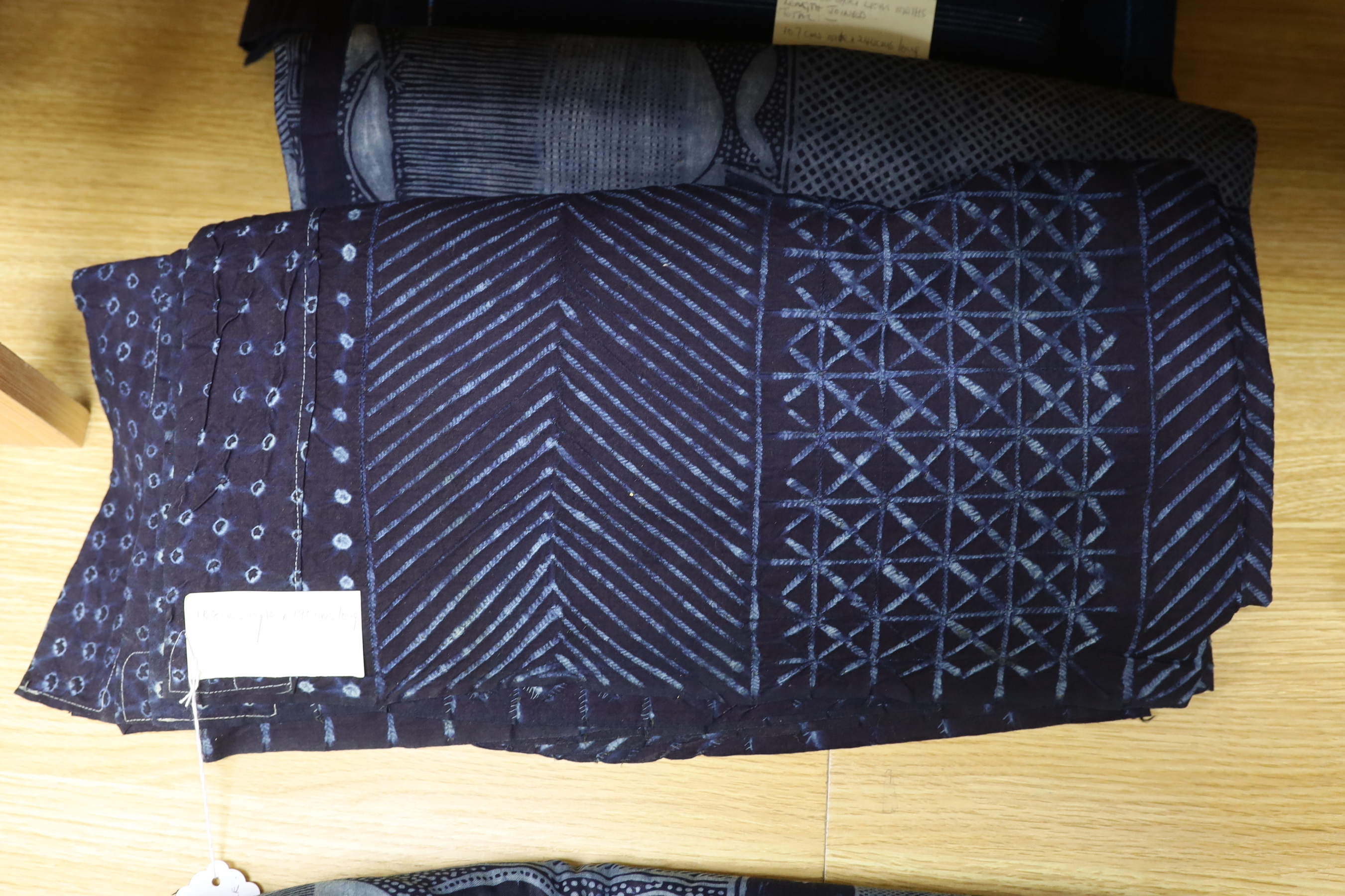 Four 20th century Nigerian Adire, indigo dyed, batik printed, cotton hangings, all with different designed motifs on short looms and two other short loom, woven indigo panels, largest cotton printed panel 180cm wide, 200